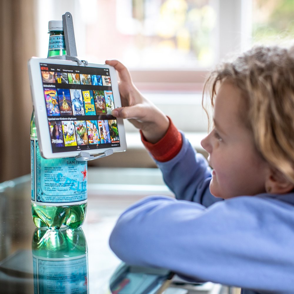 Der koziol „Idee-Fix Smartphonehalter“ al Pellegrino Flasche mit Tablet darauf; Kind spielt auf Tablet
