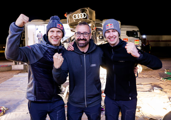 Drei Männer in Audi Sport Teambekleidung jubeln