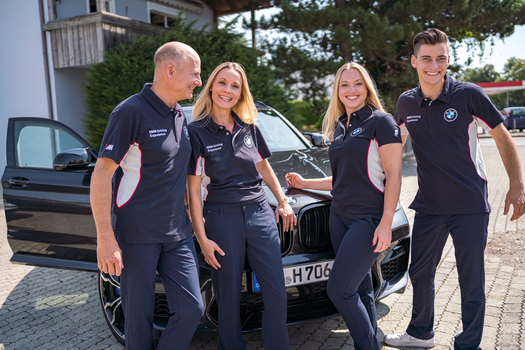 BMW Driving Experience Team im Corporate Fashion Outfit mit Logo Stick auf der Brust